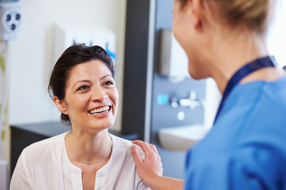 woman looking at doctor and smiling.