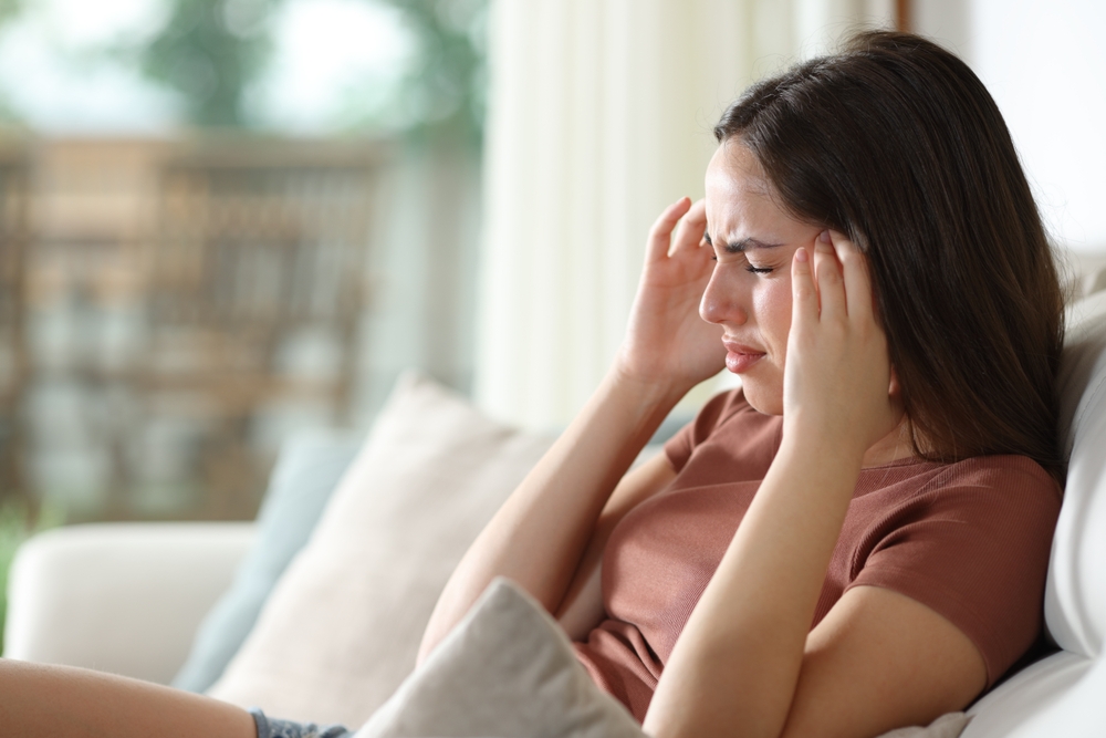 Stressed woman suffering migraine.